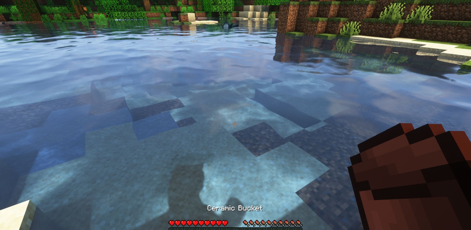 Керамическое ведро с водой в руке игрока в Minecraft